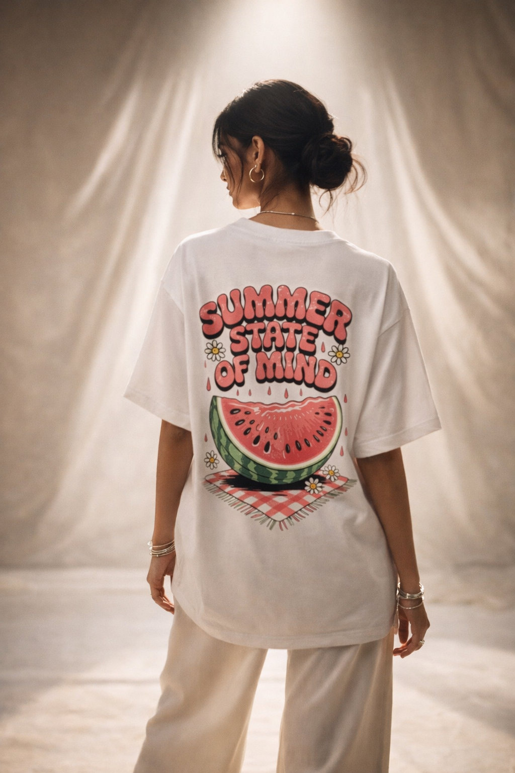 Person wearing a white t-shirt with a watermelon graphic and text, standing against a neutral background.