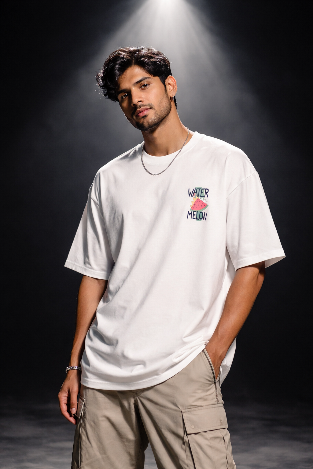 Man wearing a white t-shirt with a colorful logo on a dark background